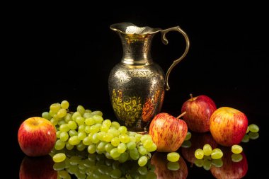 Siyah arka planda üzüm ve elmalarla dolu bir hayat.