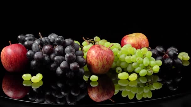 Bodegón con uvas y manzanas sobre fondo negro. — Vídeos de Stock