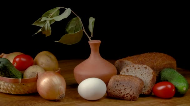 Натюрморт з овочами та хлібом на чорному тлі . — стокове відео