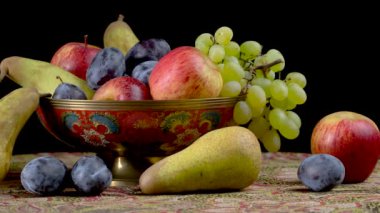 Siyah arka planda meyvelerle dolu bir hayat. armut, üzüm, elma, erik