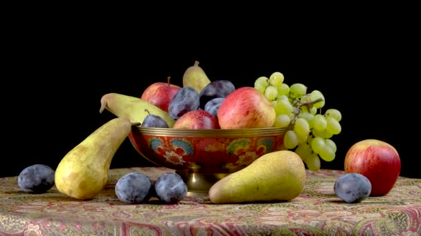 Natureza morta com frutos em um fundo preto. peras, uvas, maçãs, ameixas — Vídeo de Stock