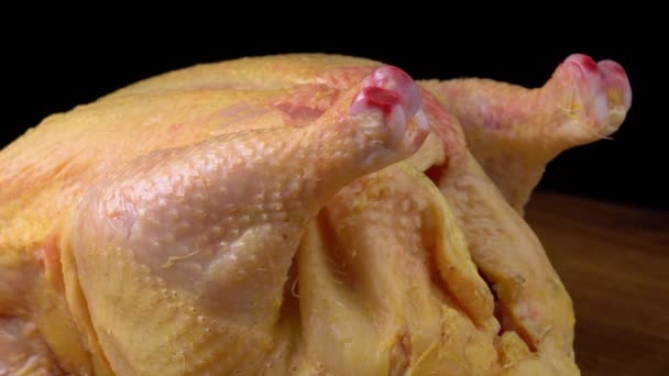 Ακατέργαστο φρέσκο εκσπλαχνισμένο κοτόπουλο αγροκτήματος σε μαύρο φόντο — Αρχείο Βίντεο