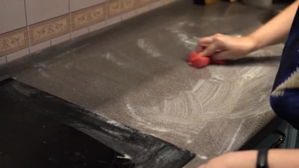 Kvinnan i köket tvättar köksbänken — Stockvideo