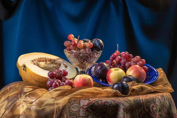 Zátiší s melounem a ovocem na tmavomodrém pozadí. — Stock fotografie