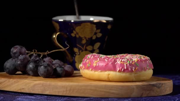 Aardbei donut en druiven op een zwarte achtergrond — Stockvideo