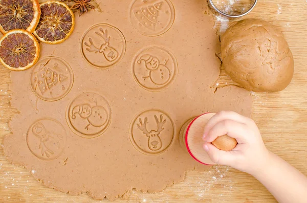 Cuisine de Noël créative de biscuits faits maison avec des mains d'enfants sur un fond en bois. — Photo
