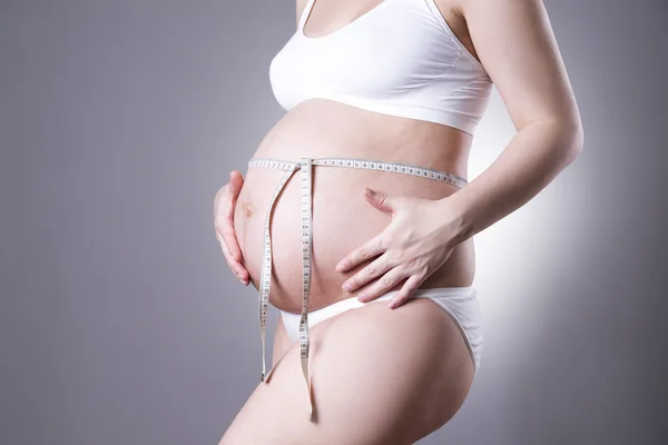Gebelik ve beslenme - teyp gri arka plan üzerinde ölçüm ile hamile kadın — Stok fotoğraf
