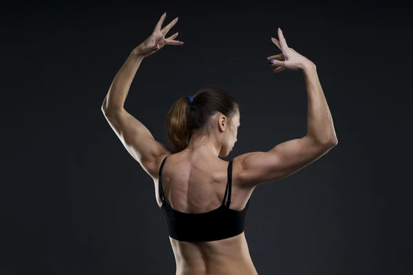 Atrakcyjny fitness kobieta na szarym tle w studio. Mięśni pleców z bliska — Zdjęcie stockowe