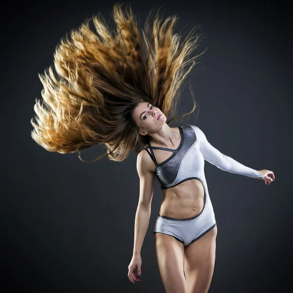 Bella giovane donna con i capelli fluenti in studio — Foto Stock