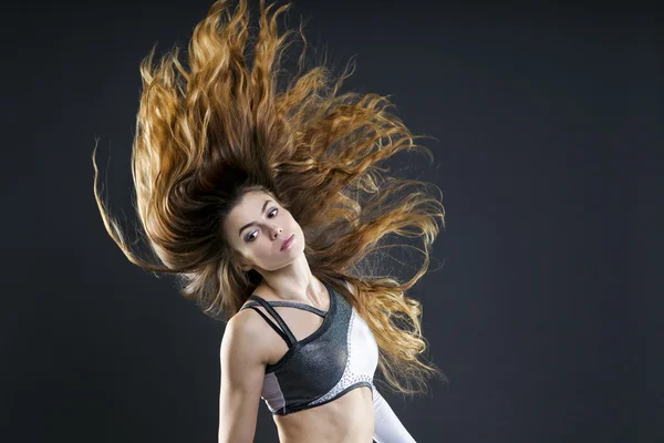 Bella giovane donna con i capelli fluenti in studio — Foto Stock