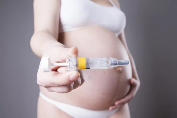 Jovem grávida a fazer uma injecção no estômago. Close-up estúdio tiro — Fotografia de Stock