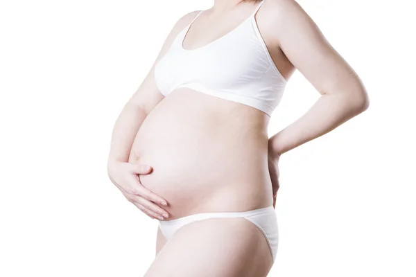 Kaukasische zwangere vrouw in witte lingerie met buikpijn geïsoleerd op witte achtergrond — Stockfoto