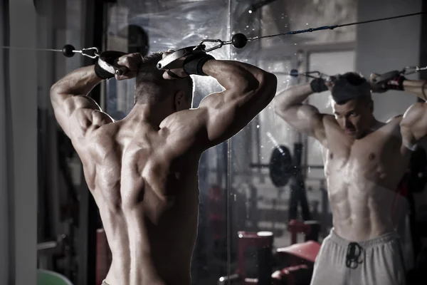 Handsome bodybuilder works out pushing up excercise in gym. Perfect muscular male body — Stock Photo, Image