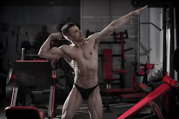 Handsome bodybuilder posing in gym. Perfect muscular male body — Stock Photo, Image