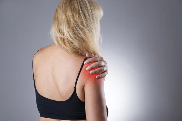 Woman with pain in shoulder. Pain in the  human body on a gray background — Stock Photo, Image