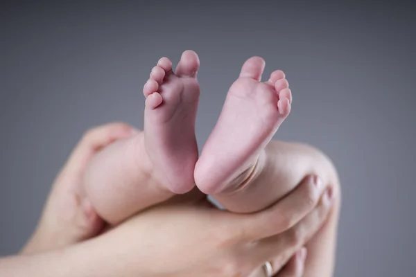 Babyfuß in den Händen der Mutter — Stockfoto