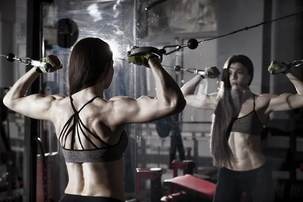 Wanita muda latihan kebugaran seksi dengan mesin latihan di gym — Stok Foto