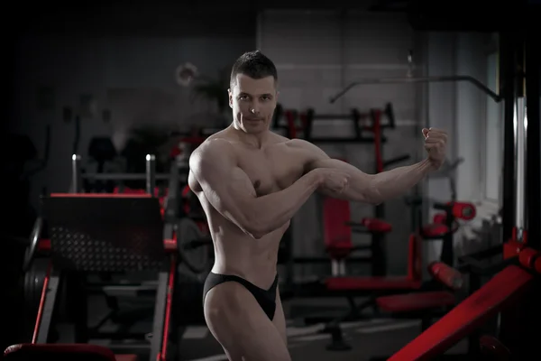 Handsome bodybuilder posing in gym. Perfect muscular male body — Stock Photo, Image