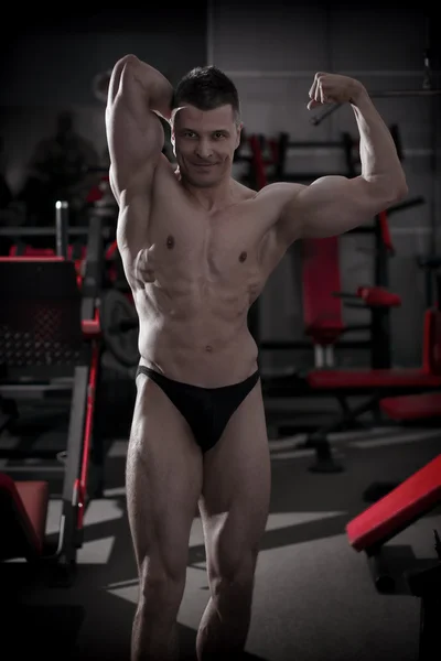 Handsome bodybuilder posing in gym. Perfect muscular male body — Stock Photo, Image