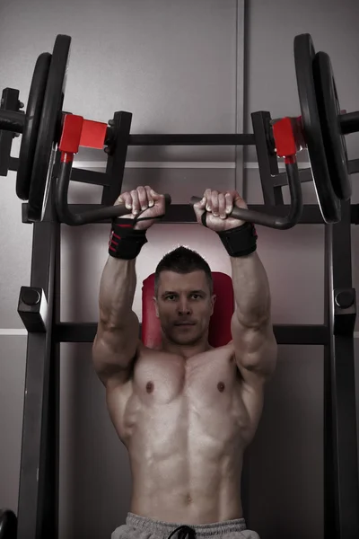 Prensa de banca. Entrenamiento de culturistas guapo en entrenador en el gimnasio —  Fotos de Stock