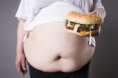 Şişman kadın büyük hamburger elinde, abur cubur kavramı ile obezite muzdarip