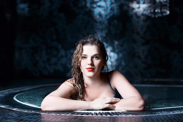 Hermosa joven rubia caucásica mujer en bikini con maquillaje impermeable relajante en la piscina caliente o jacuzzi en el centro de spa — Foto de Stock