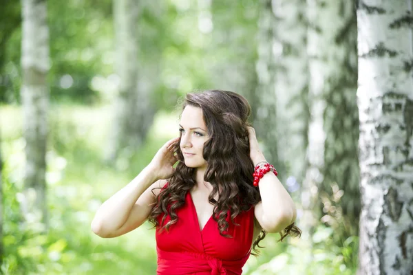 Belle jeune femme brune caucasienne en robe rouge en plein air — Photo