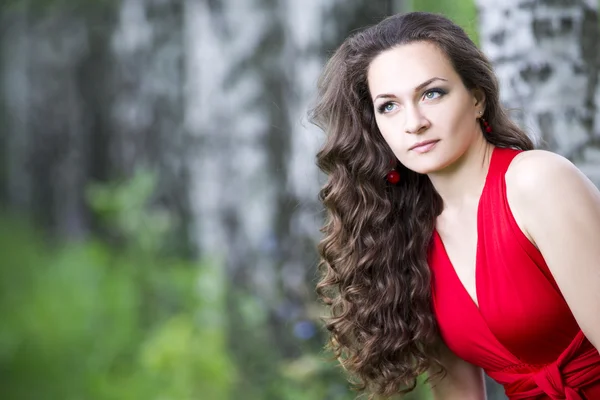 Bela jovem caucasiana morena em vestido vermelho ao ar livre — Fotografia de Stock