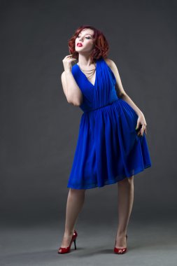 Genç güzel kızıl saçlı Kafkas kadın mavi elbiseli Studio gri arka plan, profesyonel makyaj ve saç modeli poz