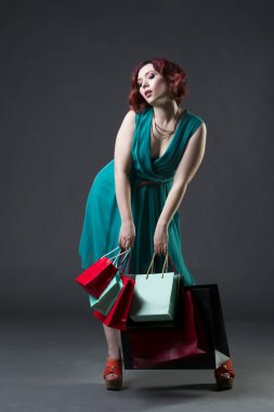 Alışverişkoliğin kavramı, aquamarine genç güzel kızıl saçlı beyaz kadın elbise gri arka plan, profesyonel makyaj ve saç modeli Studio poz
