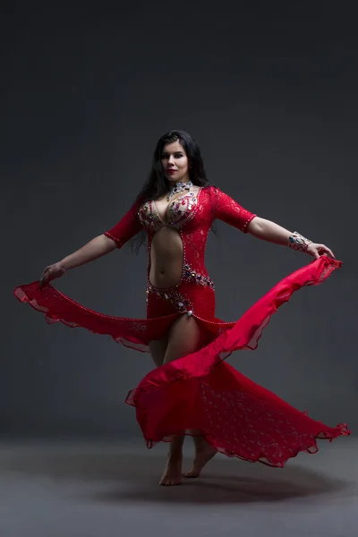 Jóvenes hermosas mujeres exóticas orientales realiza danza del vientre en vestido rojo étnico sobre fondo gris — Foto de Stock