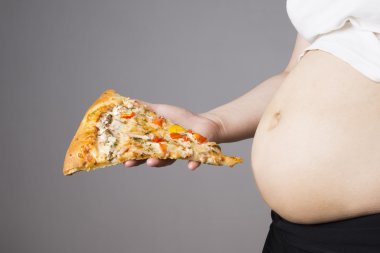Bir parça pizza elinde, obezite kavramı ile şişman kadın