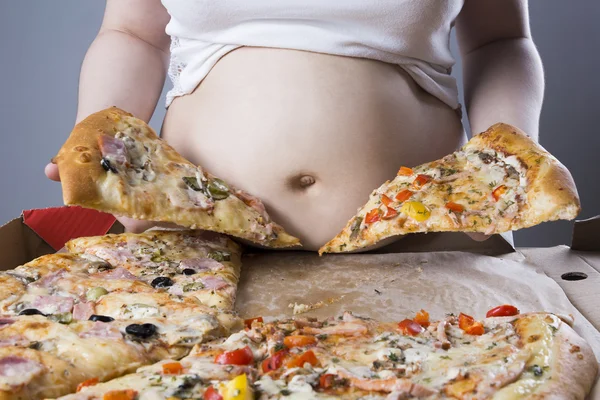 Mujer gorda con un pedazo de pizza en la mano, concepto de obesidad — Foto de Stock