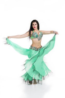 Genç, güzel, egzotik doğu kadınları etnik yeşil elbiseler içinde göbek dansı yapıyorlar. Beyaz arkaplanda izole