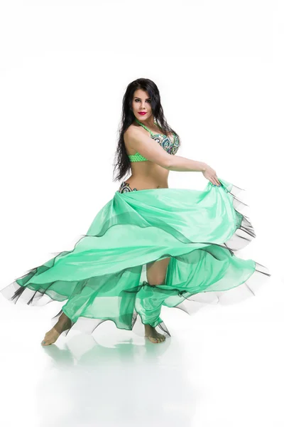 若い美しいエキゾチックな東部の女性は民族の緑のドレスでベリーダンスを実行します。白地に隔離された — ストック写真