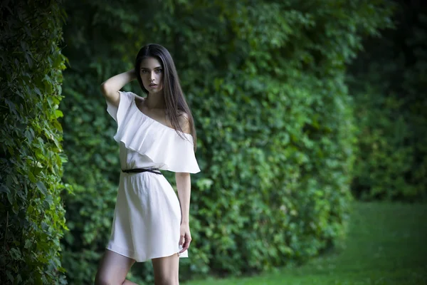 Retrato de una hermosa mujer caucásica joven en vestido blanco con hombros abiertos, piel limpia, cabello largo y maquillaje casual —  Fotos de Stock