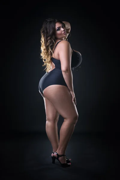 Jovem bonito caucasiano plus size modelo em maiô, xxl mulher no fundo preto — Fotografia de Stock