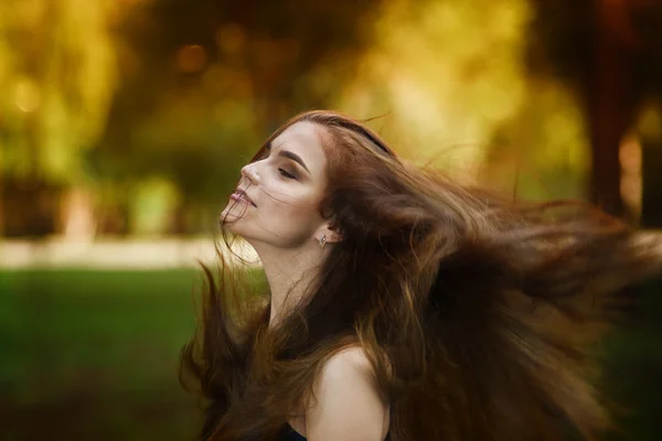 Retrato de una hermosa mujer caucásica joven con el desarrollo en el viento pelo largo, piel limpia y maquillaje casual, temporada de otoño —  Fotos de Stock