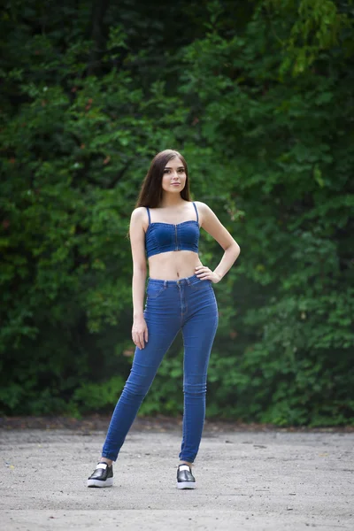 Retrato de comprimento total de uma bela jovem caucasiana em jeans azul e top jeans, pele limpa, cabelos longos e maquiagem casual , — Fotografia de Stock