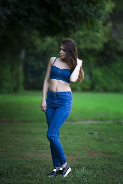 Ganzkörperporträt einer schönen jungen kaukasischen Frau in blauen Jeans und Jeans, sauberer Haut, langen Haaren und lässigem Make-up, — Stockfoto