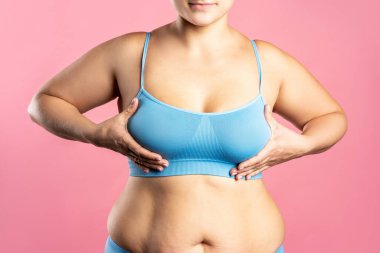 Mavi sutyenli büyük doğal göğüsler. Pembe arka planda, stüdyo çekimi.