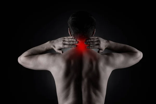 Neck pain, man with backache on black background, painful area highlighted in red