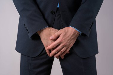 Ürolojik üreme enfeksiyonu konsepti, prostat ağrısı, protez iltihabı olan ofis çalışanı veya gri arka planda zührevi bir hastalık.