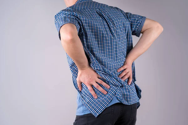 Back pain, kidney inflammation, ache in man's body on gray background