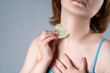 Gouache kazıyıcı, yüz masajı ve gri arka planda kaldırma