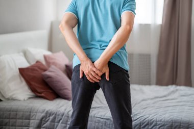 Anal ağrı, evde hemoroit geçiren bir adam.