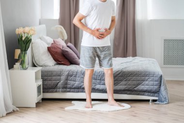 Mide ağrısı, evde acı çeken karın ağrısı olan bir adam.