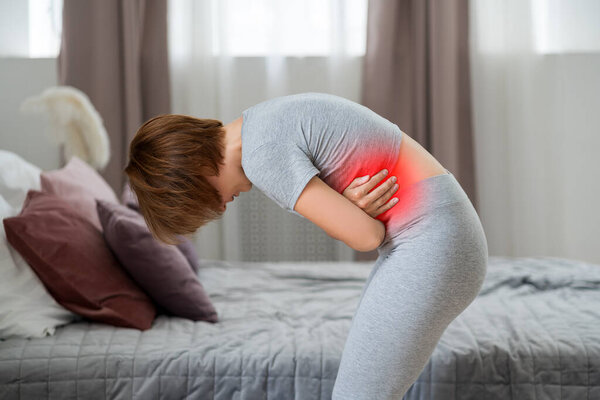 Stomach ache, symptoms of gastritis or pancreatitis, woman with abdominal pain suffering at home, painful area highlighted in red