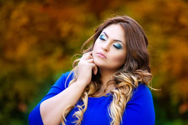 美容プラスサイズモデルで青ドレス屋外 脂肪女性で秋公園間黄色の葉 美しい髪型と化粧 — ストック写真