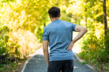 Dışarıda yürürken sırt ağrısı, böbrek iltihabı olan bir adam, sağlık sorunları kavramı.